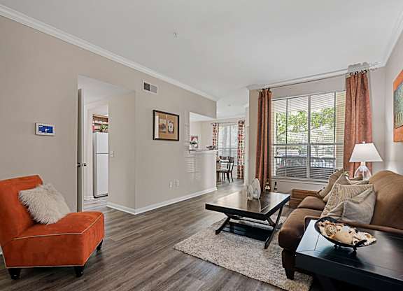 A living room with a brown couch, a red chair, and a coffee table.