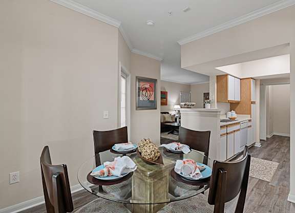 A dining room with a glass table and chairs.