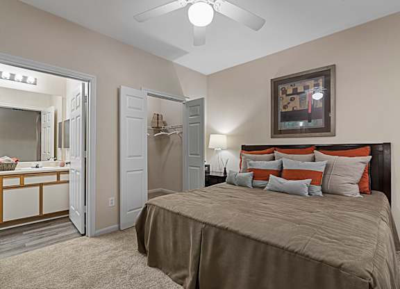 A bedroom with a bed, dresser, and mirror.