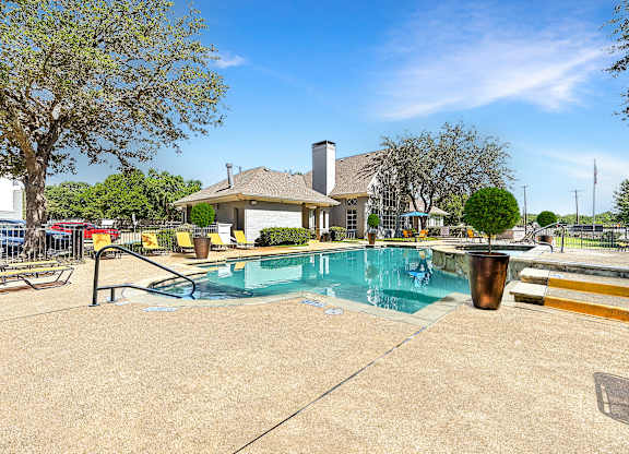 A pool area with a house in the background.