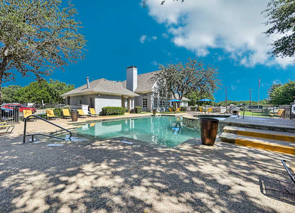 a resort style pool with a building in the background