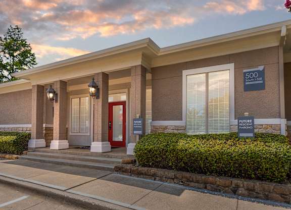 The image shows the front of a building with a red door and a sign that reads "500 Summit".
