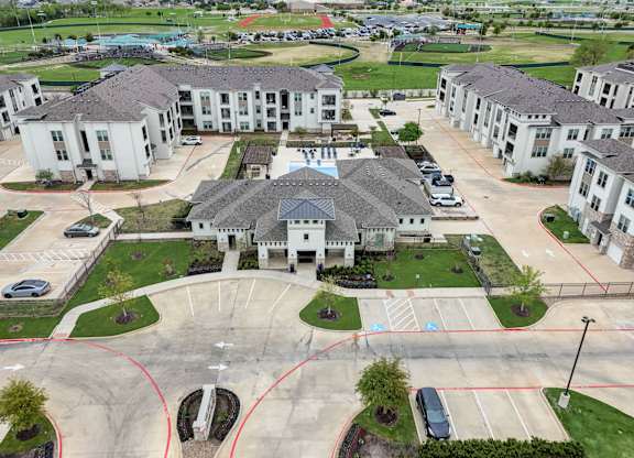 an aerial view of a neighborhood of houses with cars in a parking lot