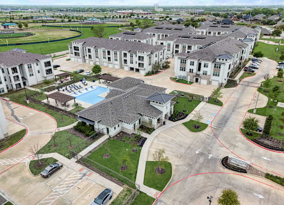 an aerial view of a group of houses and a swimming pool