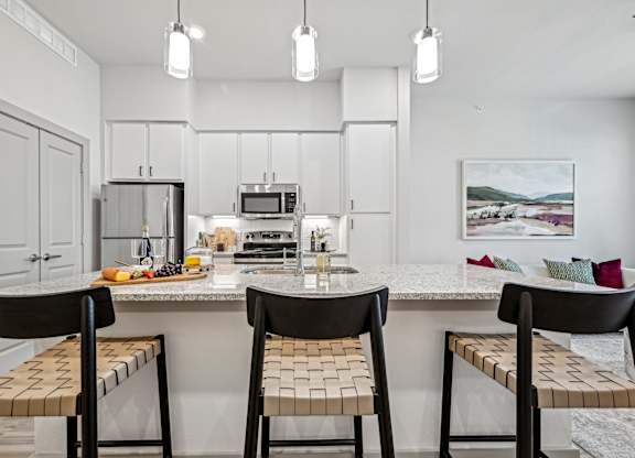 a kitchen with a marble counter top with three stools