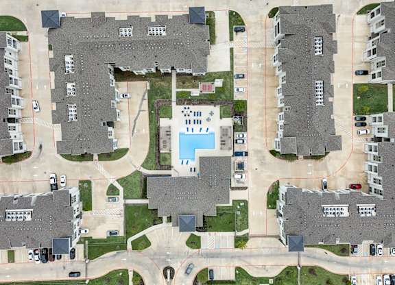 an aerial view of a neighborhood with houses and a pool
