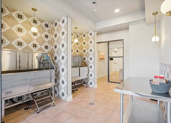 a kitchen with stainless steel appliances and a tiled wall