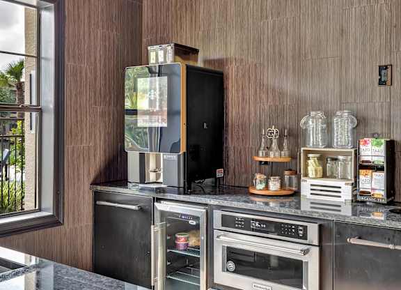 Refreshment station with countertop appliances, storage cabinetry, and tea display.