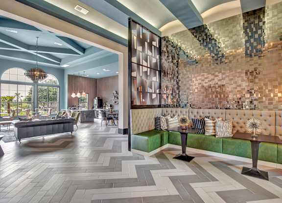 Clubhouse lounge with tufted banquette seating, modern tile floors, and open layout.
