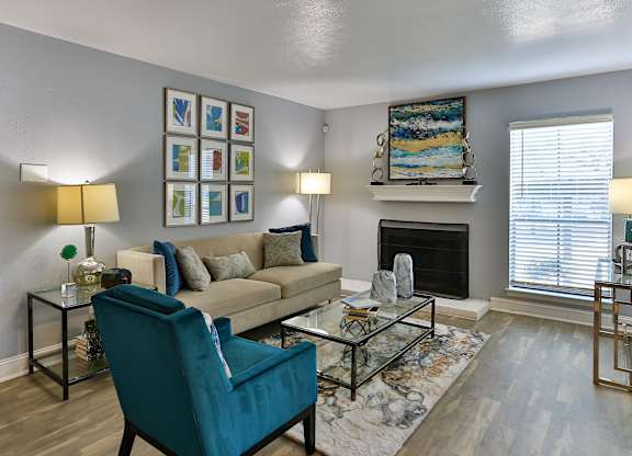 A living room with a blue chair and a fireplace.