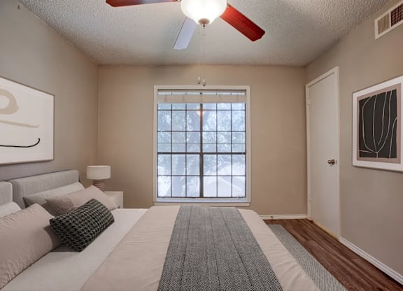 A bedroom with a large bed and a window.