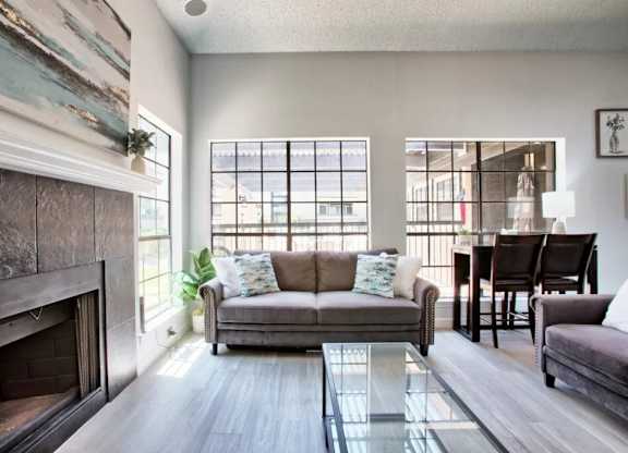A living room with a grey couch and a fireplace.