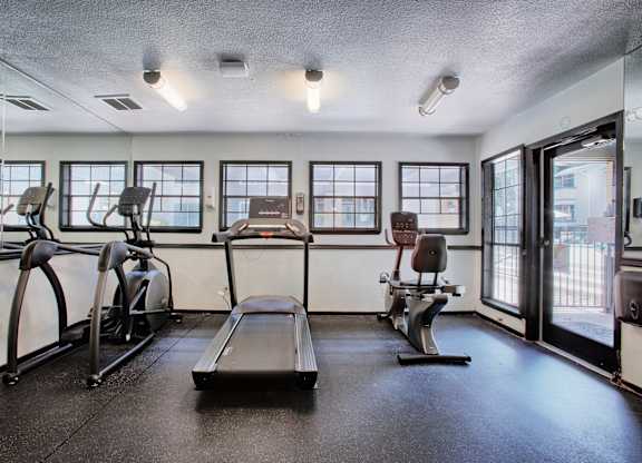 A gym with treadmills, elliptical machines, and a rowing machine.