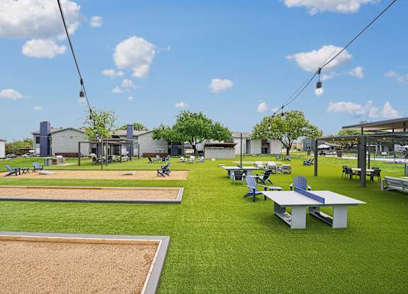 a park with picnic tables and benches on the grass