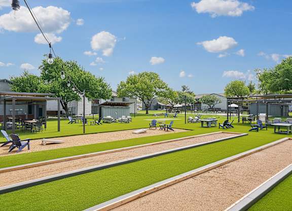 a rendering of a park with grass and tables and chairs