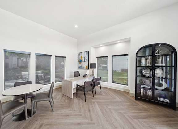 a dining room with a table and chairs and large windows