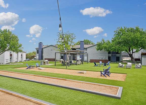 a park with a playground and picnic tables in front of a building