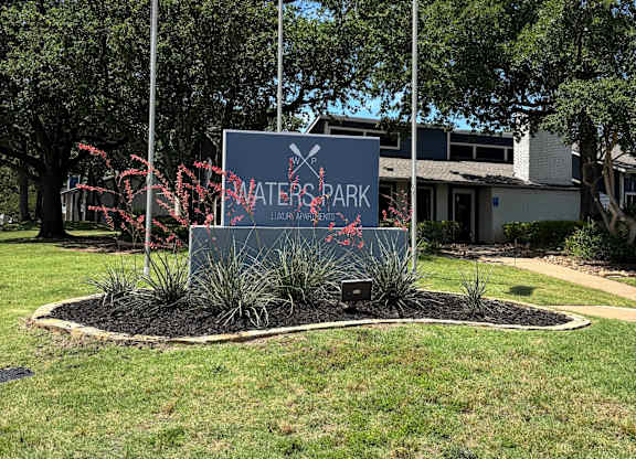 A sign that says Water Park in front of some trees.
