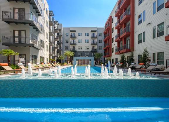 A pool with a fountain in the middle of a residential area.
