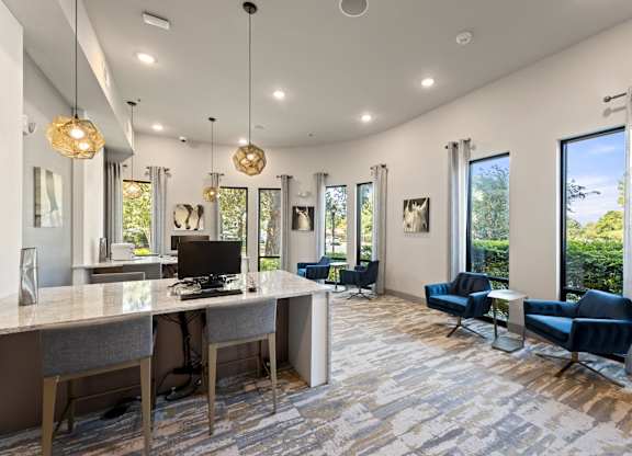 A modern home office with a desk, chairs, and a view of the outdoors.