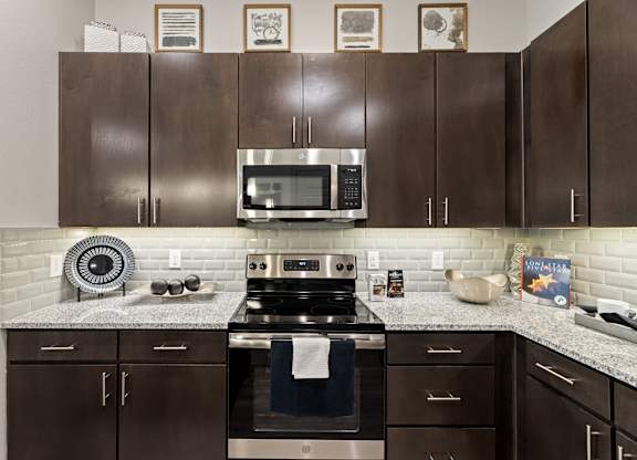 A kitchen with brown cabinets and a stove top oven.