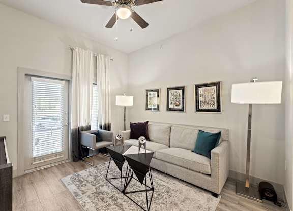 A living room with a couch, a chair, a coffee table, and pictures on the wall.