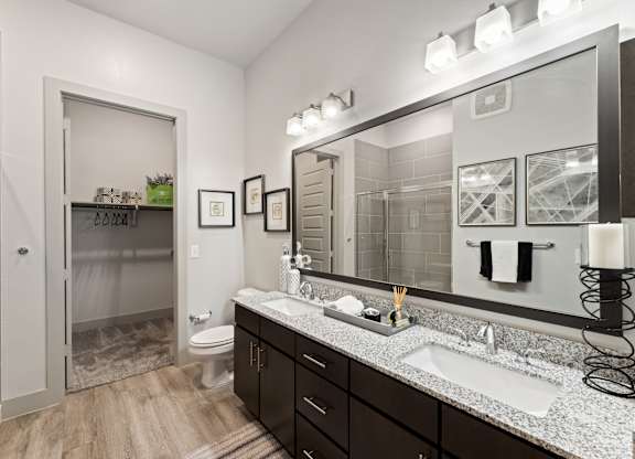 A bathroom with a sink, mirror, and toilet.