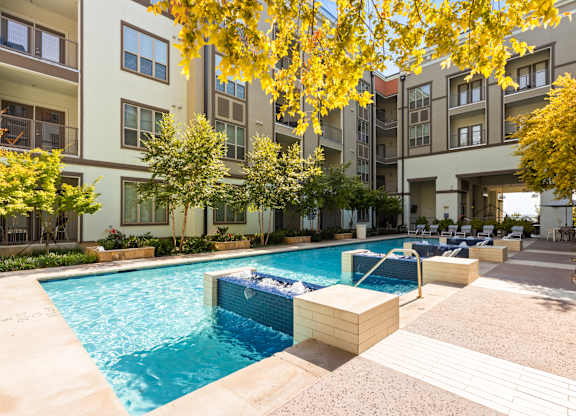 A swimming pool surrounded by apartment buildings.
