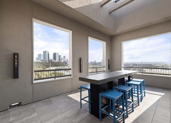 A modern kitchen with a bar stool and a view of the city.