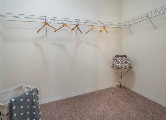 a walk in closet with white walls and carpet