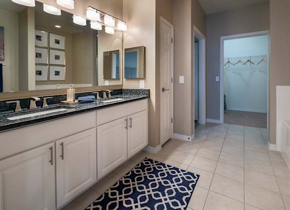 a bathroom with a large mirror and double sinks