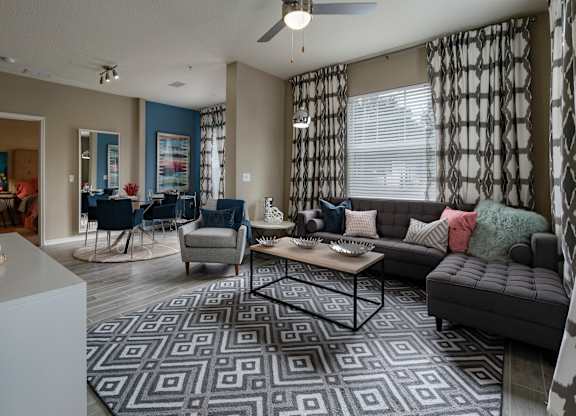a living room with a couch chairs and a coffee table in front of a window