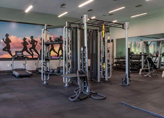 a fully equipped fitness room with free weights and cardio equipment