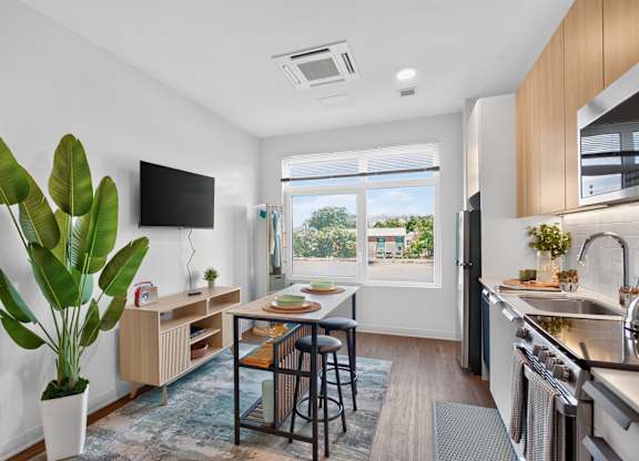 A modern kitchen with a dining table and chairs in the middle at The Indie in Allston.
