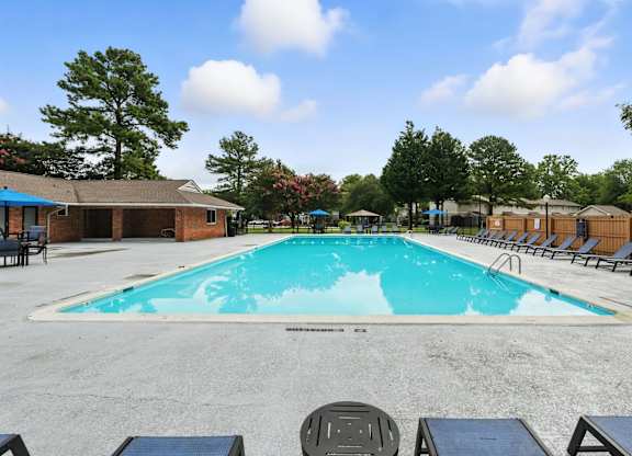 A large outdoor swimming pool surrounded by lounge chairs and trees at The Lawton Townhomes, Virginia, 23832
