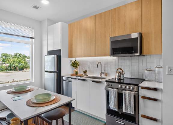 A modern kitchen with a black oven and wooden cabinets at The Indie in Allston.