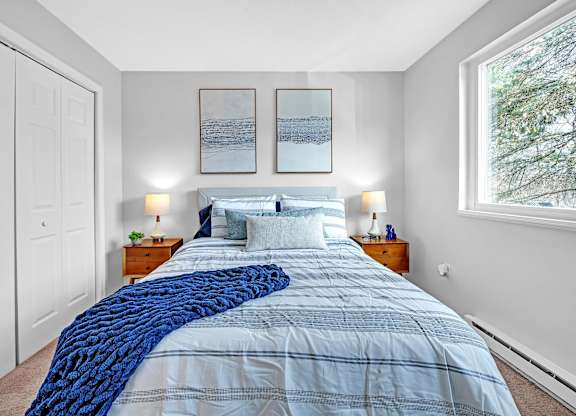 A bedroom with a large bed covered in a blue comforter.