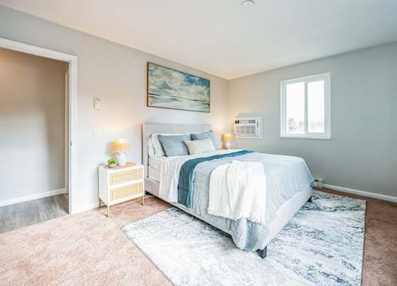 A bedroom with a large bed and a painting on the wall.