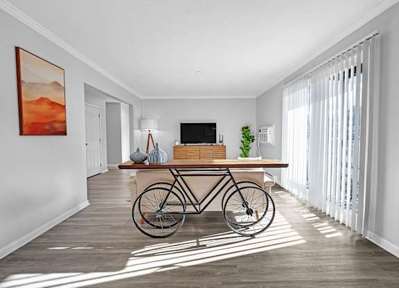 A room with a bicycle leaning against the wall and a painting hanging above it.