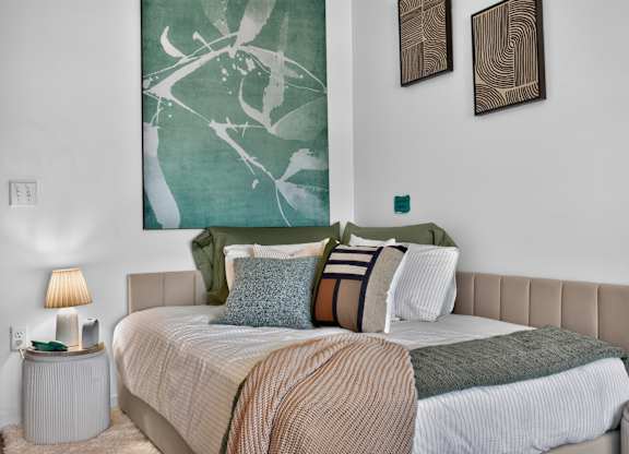 A bedroom with a large bed and two wall art pieces at The Indie in Allston.