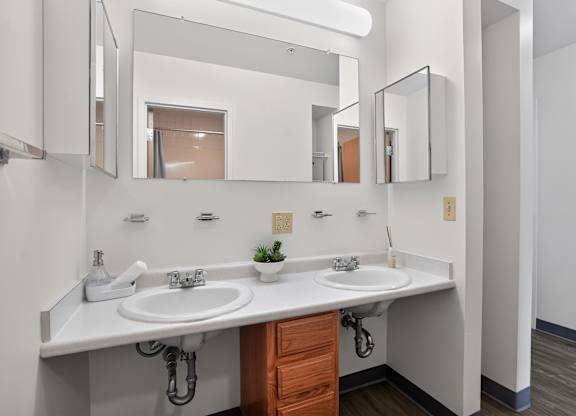 A bathroom with a white counter top and a white sink.