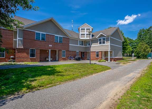 A large two-story building with a driveway in front.