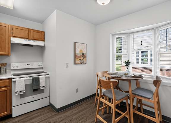 A kitchen with a dining table and chairs.