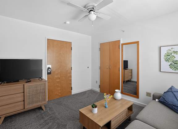 A living room with a television, a couch, and a coffee table.