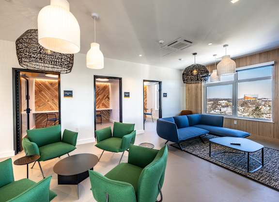 A living room with green chairs and a blue sofa.