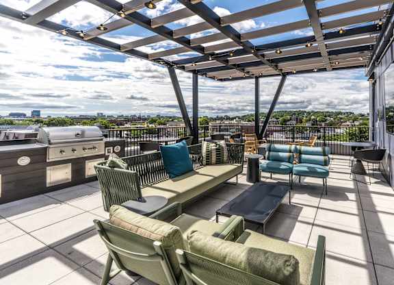 A patio with a table and chairs overlooking a cityscape.