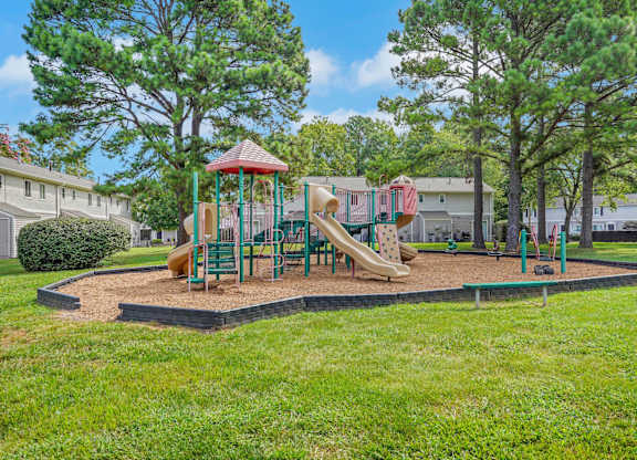 A playground with a slide, swings, and a roundabout.