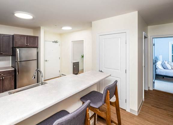 a kitchen with a large counter and a stainless steel refrigerator at Atlantic Pointe, Brunswick Maine