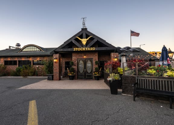 the facade of The Stockyard  restaurant with a flag at dusk