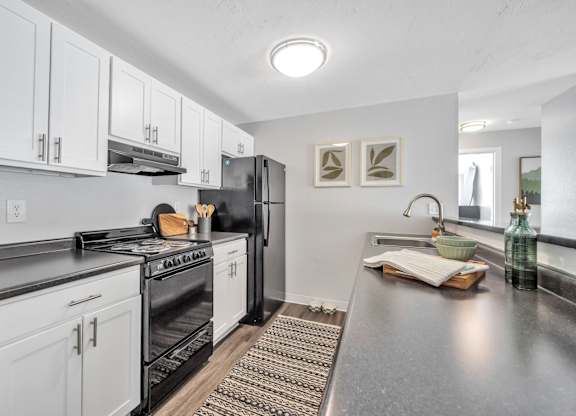 A modern kitchen with white cabinets and stainless steel appliances.